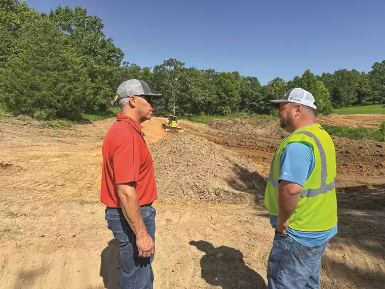KSM Territory Manager Peyton Chatham (left) talks with Adams Tanks & Lease Services owner Adam Branch on a site near Okmulgee, Okla.