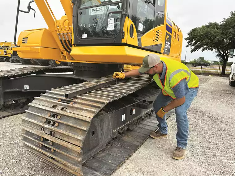 KSM PSSR Marc Owens checks track tension with a straight edge and a ruler.